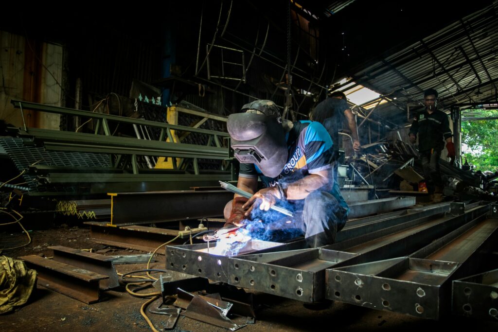 A professional welder demonstrates precision and skill in a metal workshop in Jakarta, Indonesia.